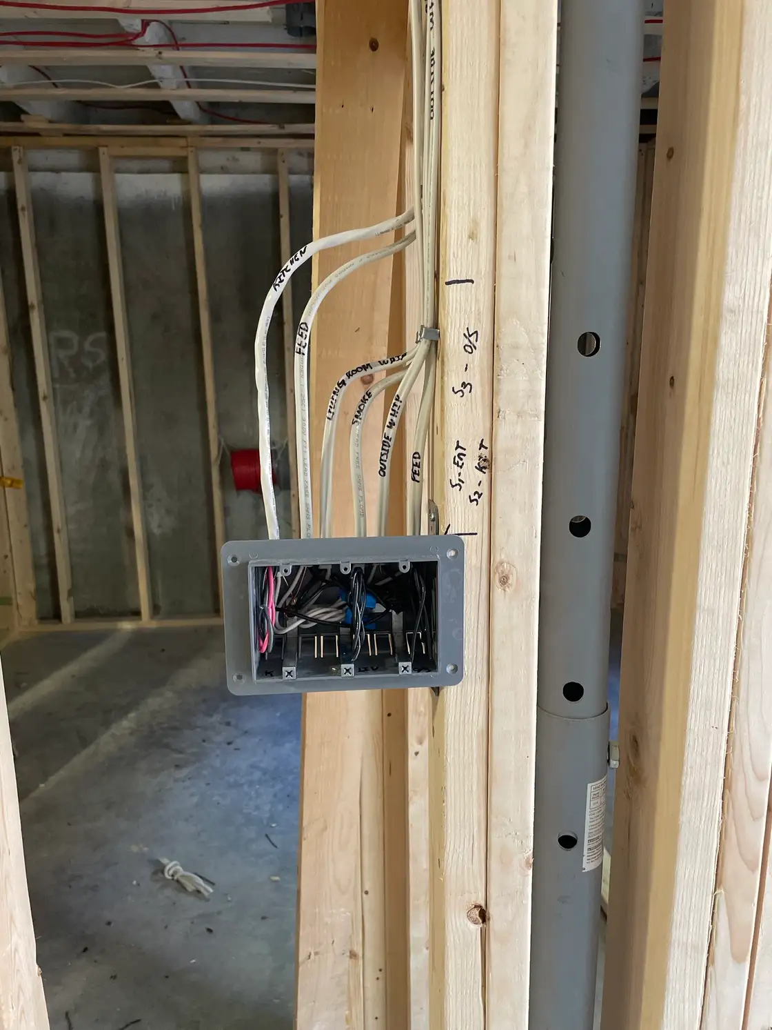 Rough-in device box on a stud with every cable labelled by circuit and room