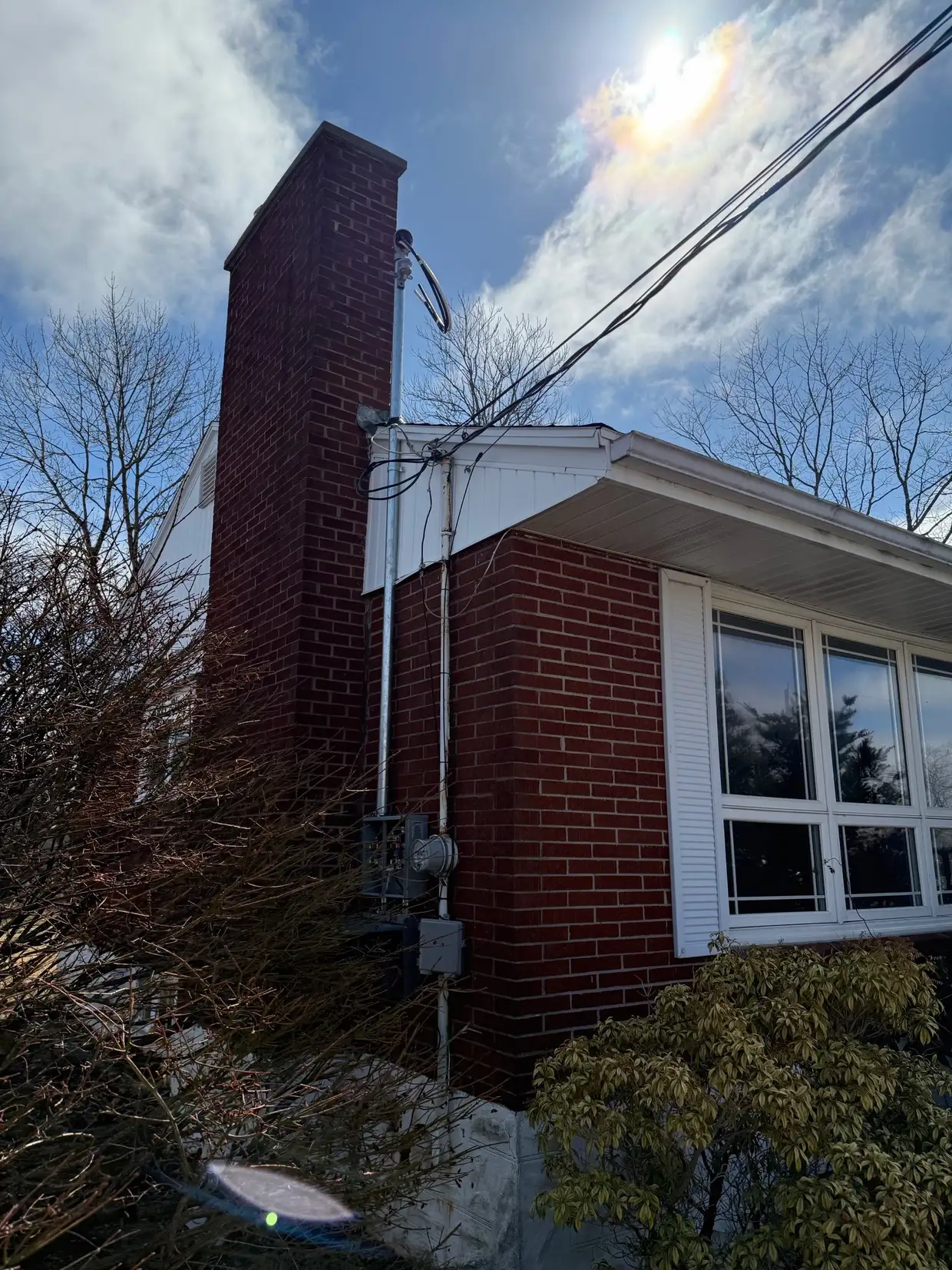 Completed service mast and meter on a brick bungalow beside the chimney
